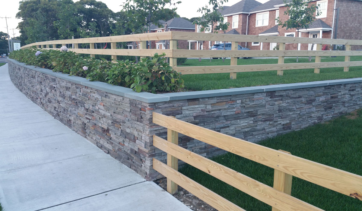 Another view of parking lot retaining wall with stone facing and Bluestone caps.